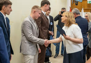 Zdjęcie wyróżnionych uczestników, uczniów Technikum nr 1 w Tomaszowie Mazowieckim, w projekcie „Młodzi zawodowcy – program stypendialny Województwa Łódzkiego” odbierających gratulacje.
