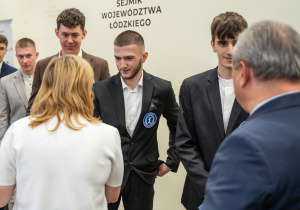 Zdjęcie wyróżnionych uczniów Technikum nr 1 w Tomaszowie Mazowieckim biorących udział w projekcie „Młodzi zawodowcy – program stypendialny Województwa Łódzkiego” odbierających gratulacje.