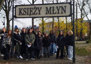 Zajęcia terenowe. Zdjęcie grupowe pod tablicą Księży Młyn