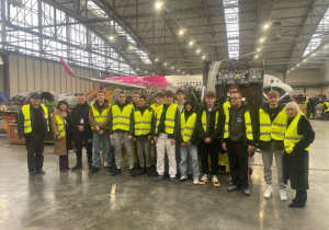 Uczestnicy wizyty studyjnej z opiekunami w hangarze LS Technics