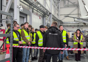 Uczestnicy wizyty studyjnej w hangarze w trakcie instruktarzu na temat przestrzegania zasad BHP i obowiązujących w firmie LS Technics procedur