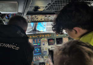 Uczestnicy wizyty studyjnej w kokpicie serwisowanego samolotu