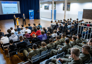 Spotkanie informacyjne o projektach rozpoczynających się w ZSP 1. Na trybunach uczniowie mechatronicy i mechanicy wraz z prowadzącymi spotkanie na auli